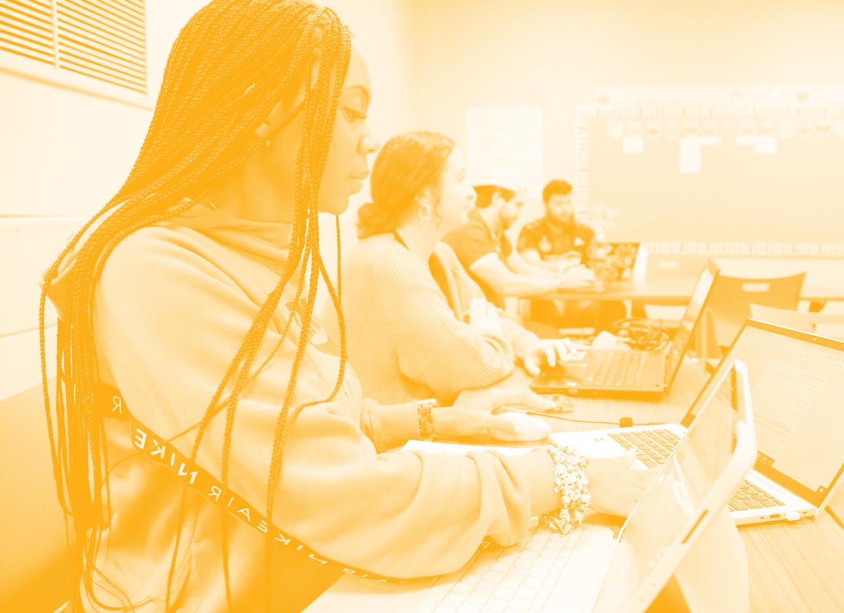 A yellow duo-tone picture of a female student working at her desk